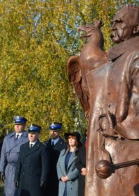 Komendanci namysłowskiej Straży Pożarnej i Policji stoją na placu przy pomniku Józefa Piłsudskiego.
